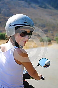 Gorgeous young woman on the scooter wearing helmet