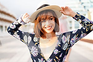 Gorgeous young woman smiling broadly with healthy white teeth, wearing summer hat. Happy female