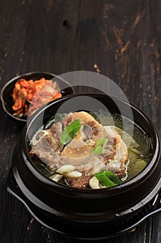 Gori Gomtang  or Korean Beef Oxtail Stew Soup, Served in the Black Korean Bowl with Kimchi and Sliced Green Onion