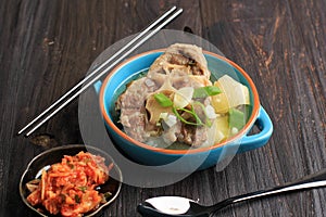 Gori Gomtang Sokkori Gomtang or Korean Beef Oxtail Stew Soup, Served in the Blue Bowl with Kimchi and Sliced Green Onion