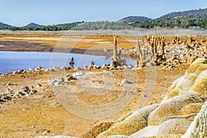 Gossan Reservoir with orange stalagmites on shore, Andalusia, Sp