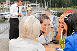 Gossiping women sitting at harbor bar