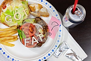 Got fat? letters on a juicy burger Unhealthy eating. Junk food concept