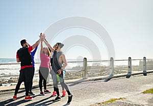 We got this one in the bag. a group of young cheerful friends forming a huddle before a fitness exercise outside during