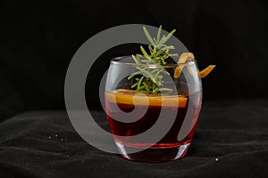 Gotfather cocktail with bourbon whiskey, amaretto, orange wedge and rosemary