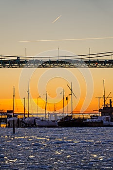 Gothenburg - sunset over fishing and sailing boats on frozen Gota river at Hisingsleden Bridge during winter photo