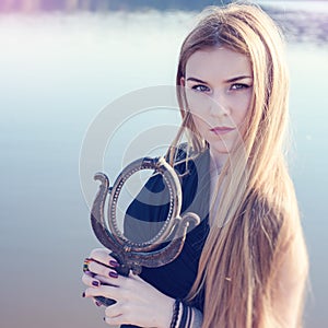 Gothic girl with long red hair and old mirror