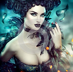 Gothic sexy young woman. Halloween. Beautiful model girl with fantasy makeup in goth costume with black feathers photo