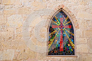 Gothic style church window with stained glass/ red cross made of stained glass