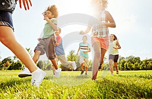 Gotta catch up to all the fun. a group of diverse and happy kids playing together outside.