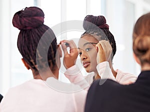 Gotta get these brows together. a young ballerina applying cosmetic products onto her eyebrows.