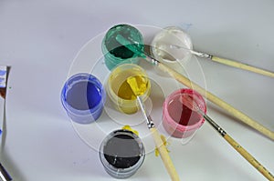 gouache paint brushes and children's drawings. photo child paints a brush with watercolor honey paints. children's art