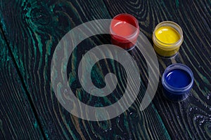 Gouache set for school. Tins of paint lie on pine boards