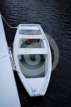 Gouda, South Holland/The Netherlands - February 7 2021: Green boat floating in the water of the canal now completely covered in