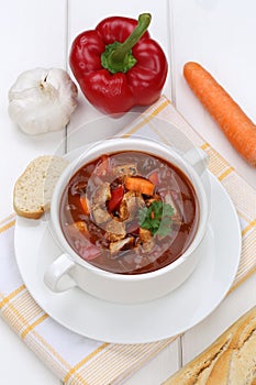 Goulash soup with baguette, meat and paprika in cup