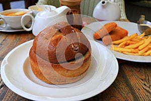 Goulash soup in bread pot, plate. Original dish in restaurant, cafe. Delicious hearty meat dish of Czech, Bulgarian, Romanian