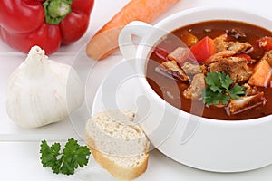 Goulash soup with meat, baguette closeup