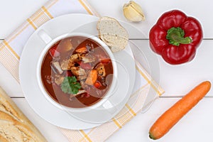 Goulash soup with meat and paprika in cup from above