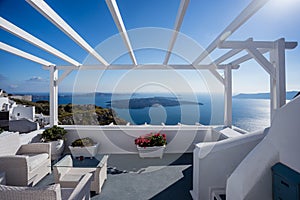 Gourgeous balcony view in white walled resort in Santorini, Greece, with ocean and cliffs in the background