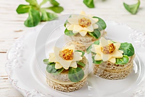 Gourmet canapÃ©s of bread with cheese, herbs and sweet mustard. Tasty snack for gourmets in a white plate. Antipasti. Selective