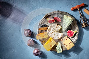 Gourmet cheese board with fruit and a shadow of a glass of red wine