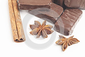 gourmet chocolate bonbons with anise and cinnamon sticks isolated on white background