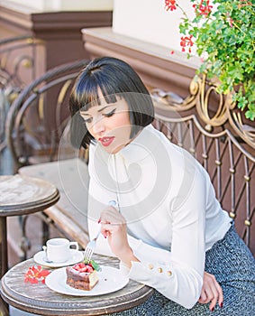 Gourmet concept. Delicious gourmet cake. Woman attractive brunette eat gourmet cake cafe terrace background