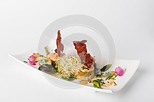 gourmet cuisine with flowers spanish jamÃ³n on a white dish and white background photo