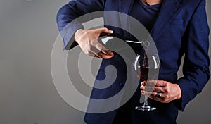 Gourmet drink bottle, red wine glass, sommelier, tasting. Waiter pouring red wine in a glass. Sommelier man, degustation