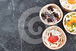 Gourmet food Snack Tartlet Creamy goat cheese Dried Fruit Appetizer Dark concrete background Copy space