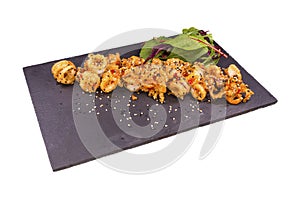 Gourmet fried squid Yakuza and sesame on a black stone plate