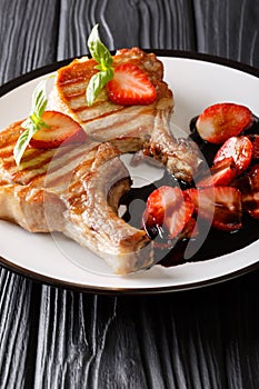 Gourmet grill juicy pork chop served with balsamic strawberry cl