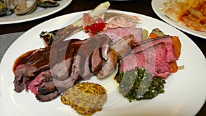 Gourmet grilled dishes. Assorted meats with sauces.