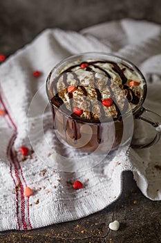 Gourmet Hot Chocolate with Heart Candies in Glass Mug with Whipped Cream on a Dark Background