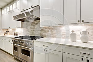 Gourmet kitchen features white cabinetry