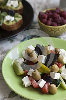 A gourmet lunch: guacamole sandwiches, raspberries and a greek salad