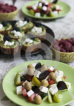 A gourmet lunch for two: guacamole sandwiches, raspberries and a greek salad