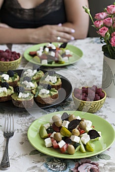 A gourmet lunch for two: guacamole sandwiches, raspberries and a greek salad