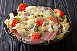 Gourmet meal: Fettuccine pasta with fried tuna steak and vegetables closeup. horizontal