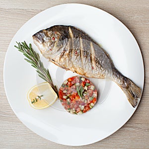 Gourmet Mediterranean seafood dish. Grilled fish gilthead with v photo