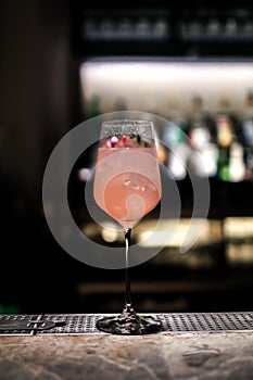 A gourmet mixed drink cocktail of sweet pink lemonade vodka and gin martini, garnished