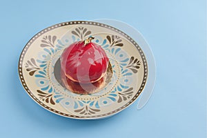 Gourmet red chocolate covered dessert for celebration or valentines day. Served on a unique plate. Copy space banner.