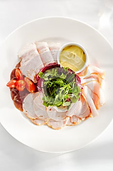 Gourmet, restaurant, delicious dinner food - close up of Sliced Meats with Rocket Salad and Tomatoes.