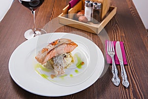 Gourmet roasted salmon steak baked in the oven, served on a pillow of risotto and red caviar as a delicious seafood dish