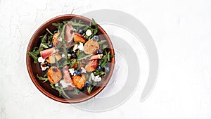 Gourmet salad with blue cheese, peaches, jamon ham and arugula on a light background, Flat lay. Banner. Top view