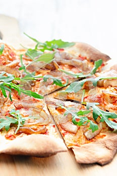 Gourmet thin crust pizza with fresh rocket and caramelised onion