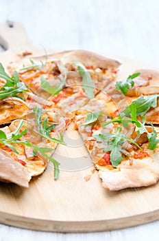 Gourmet thin crust pizza with fresh rocket and caramelised onion photo