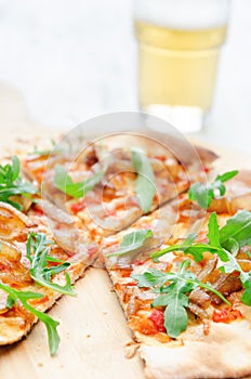 Gourmet thin crust pizza with fresh rocket and caramelised onion photo