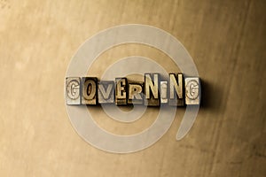 GOVERNING - close-up of grungy vintage typeset word on metal backdrop