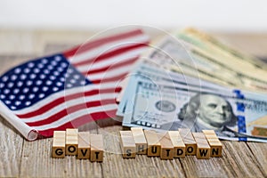 Government Shutdown USA concept with American flag and money bills on white background and wooden board